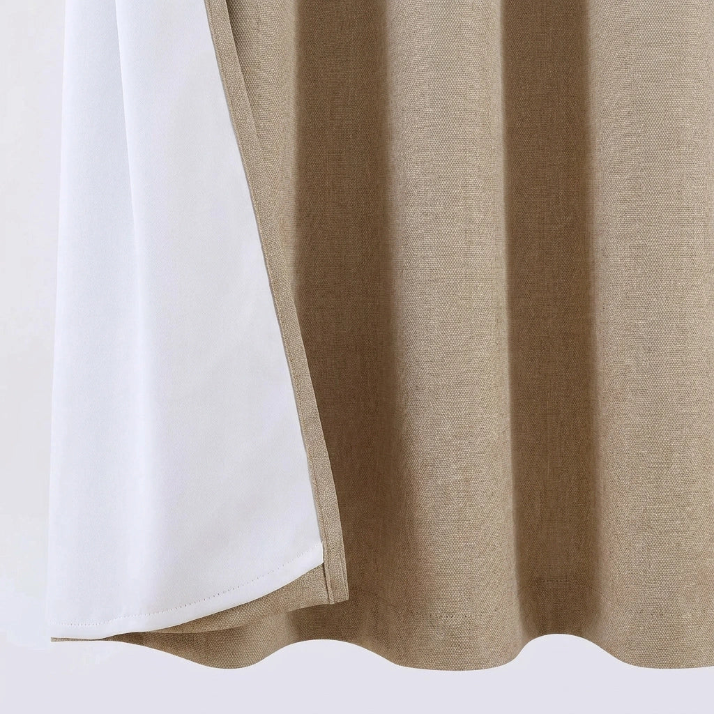 Beige blackout curtain material with white lining, showing stitched hem detail, smooth drape, and room privacy curtain construction.
