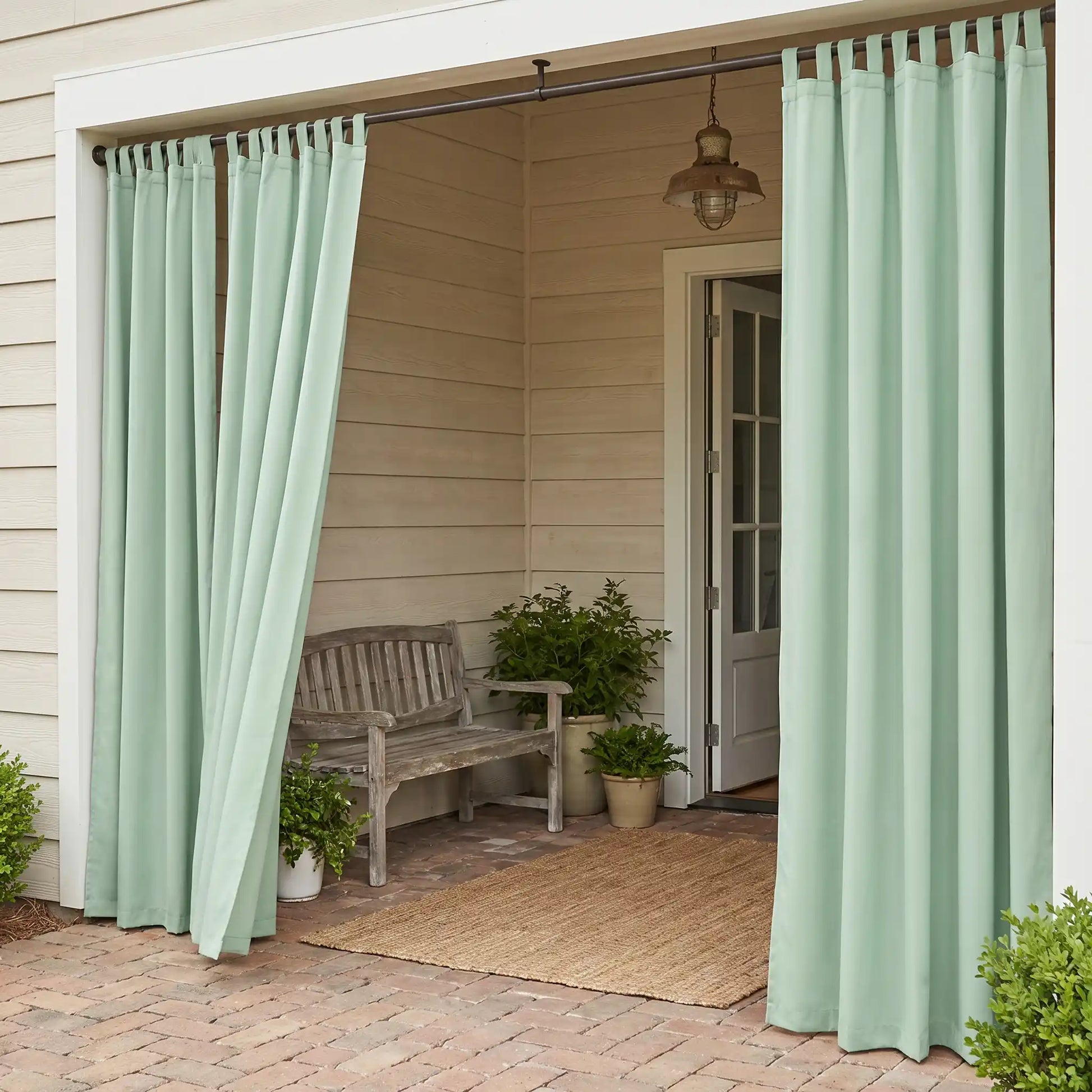 DWCN Official tab top waterproof outdoor curtain hanging outside, showcasing durable fabric and waterproof design for outdoor privacy.