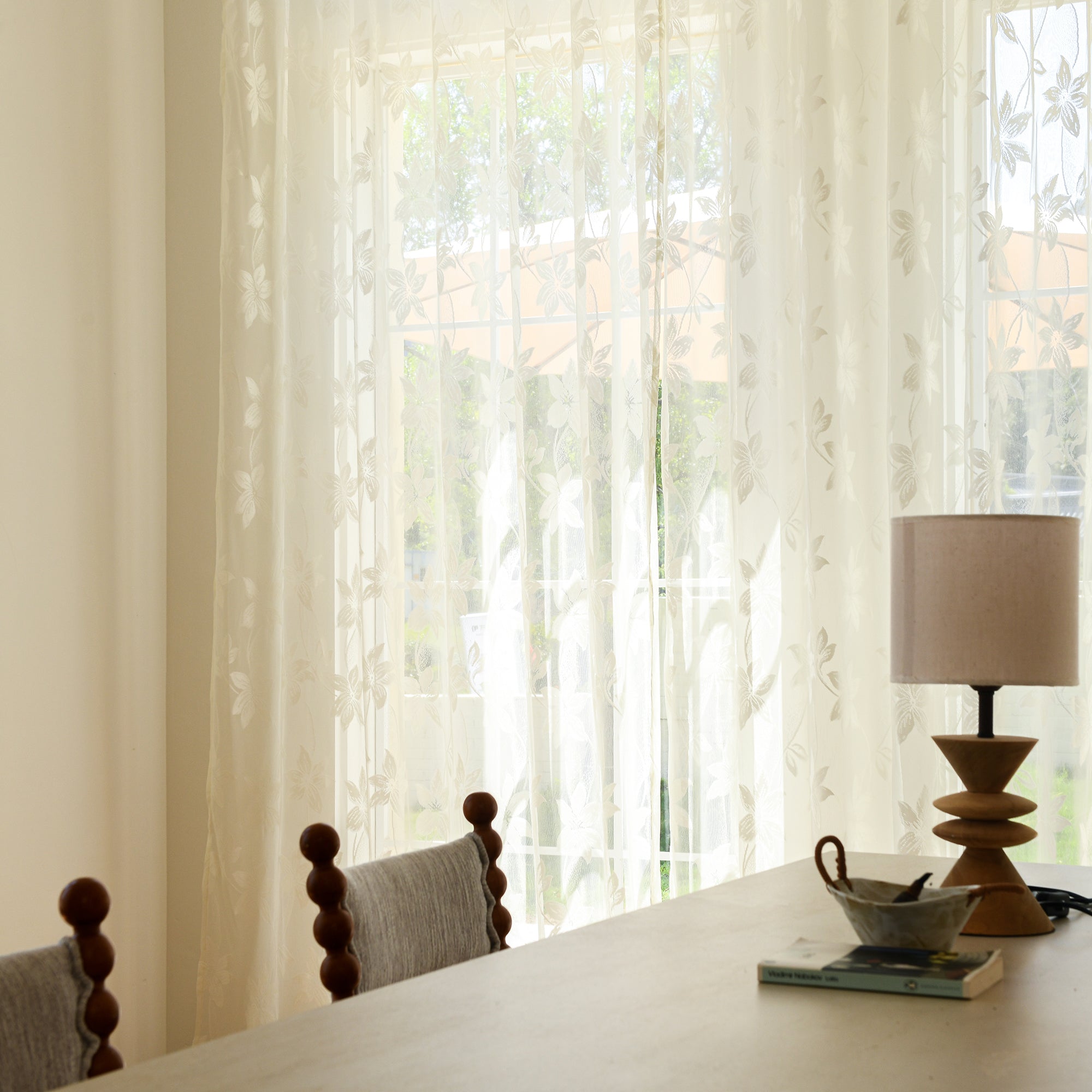 Semi-sheer lace curtains creating soft, elegant atmosphere