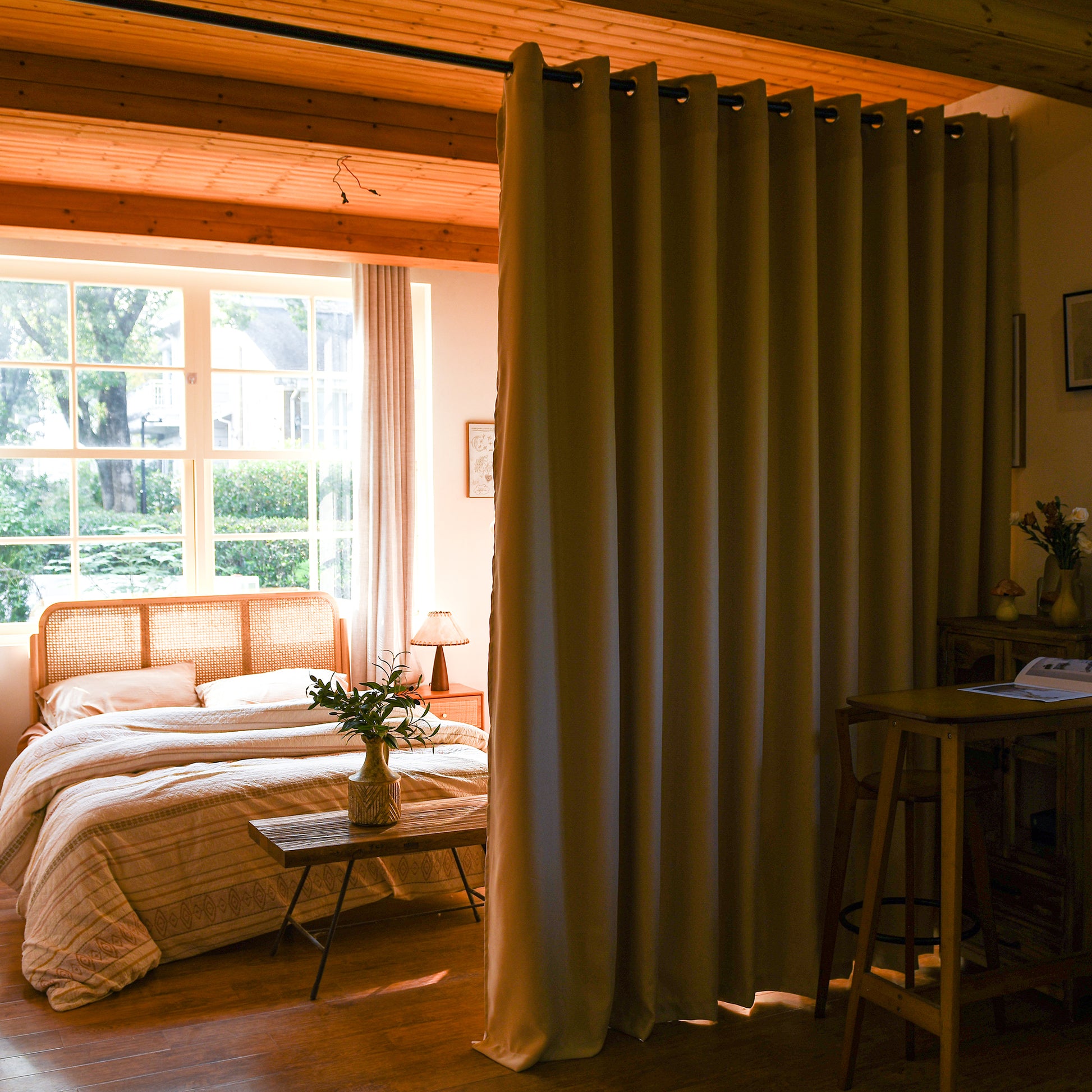Blackout room divider curtains creating private sleeping space in studio