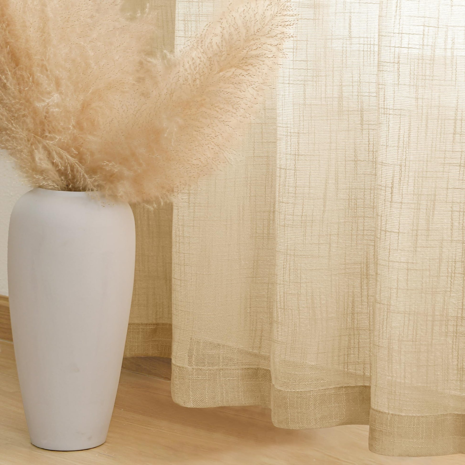 Light-colored DWCN Official custom linen sheer curtains with solid design hanging near a window, showcasing elegant, semi-transparent fabric.